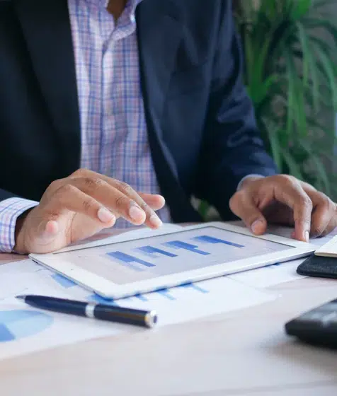 An image of a man looking at reports on a tablet device