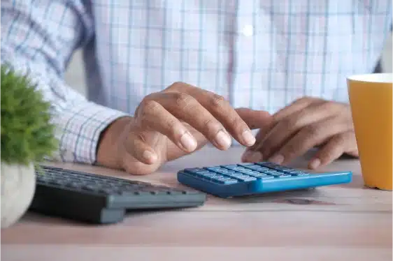 An image of someone calculating finances on a calculator.