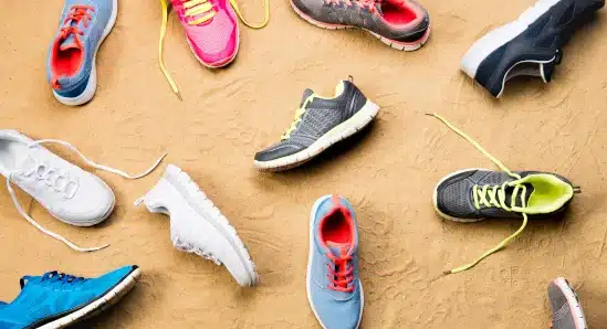 An image of various shoes on sand