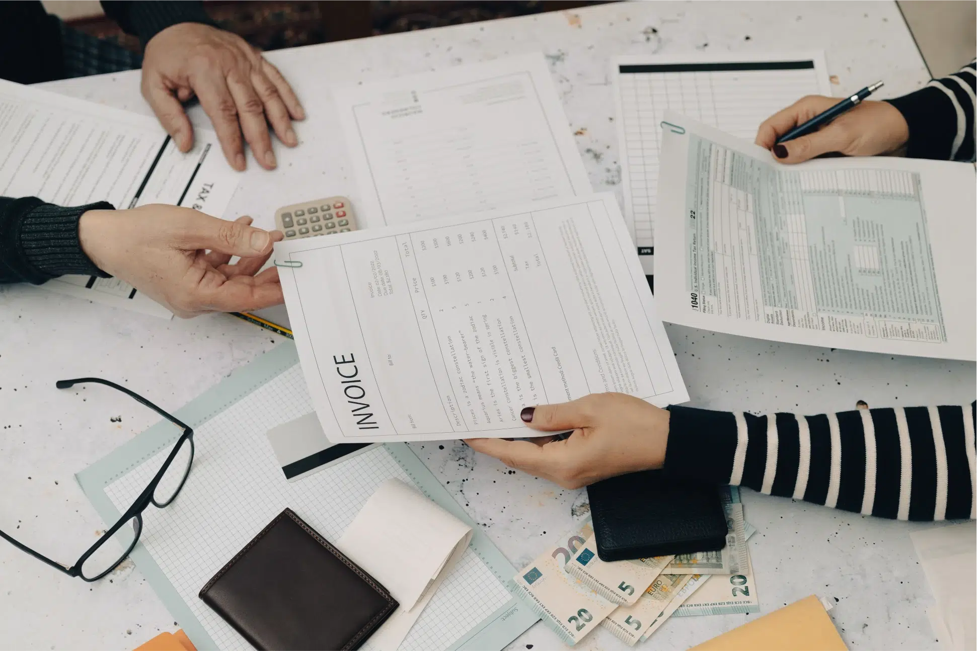 A large image of two people having a look at invoice papers.