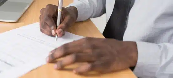 An image of a person signing a piece of paperwork.