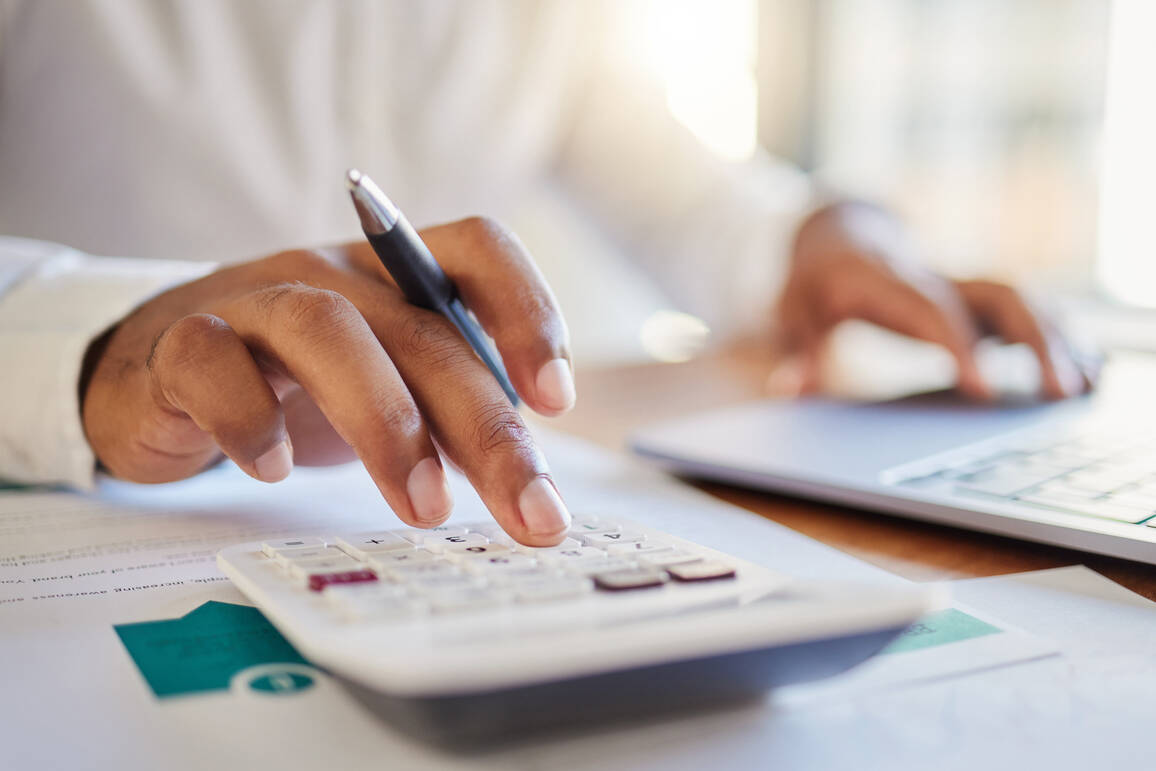 a picture of a man making calculations for business finances with a calculator
