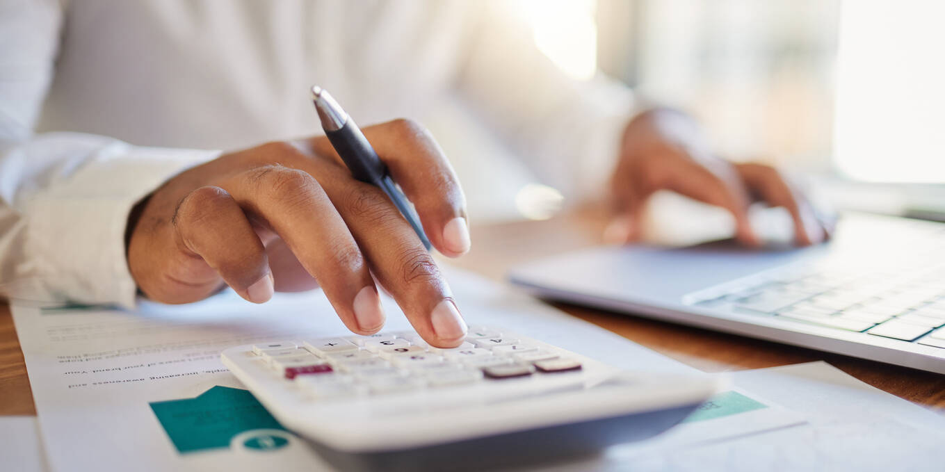 a picture of a man making calculations for business finances with a calculator