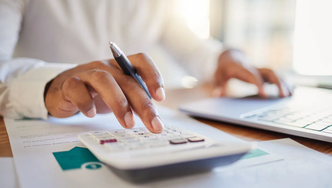 a picture of a man making calculations for business finances with a calculator
