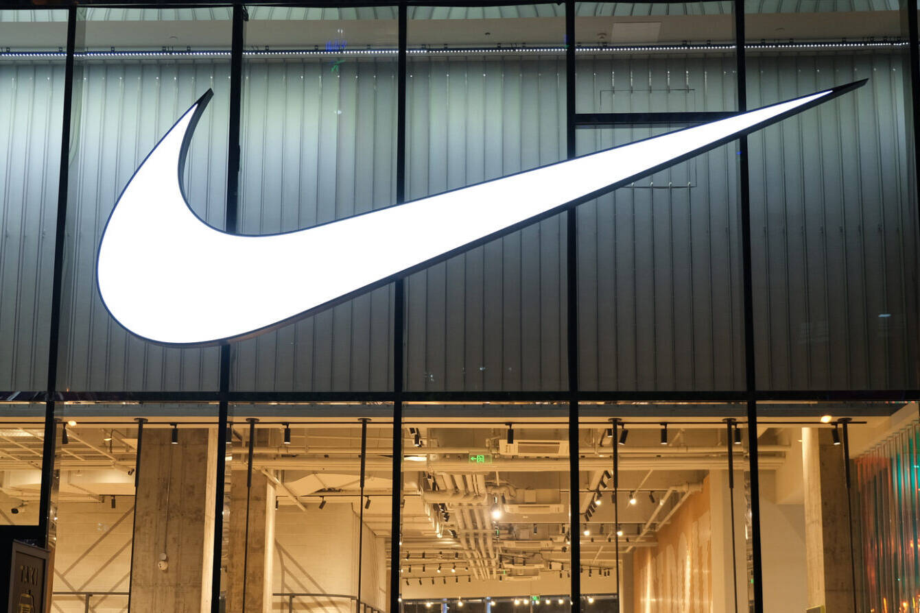 Large NIKE store at night with many people‘s silhouette